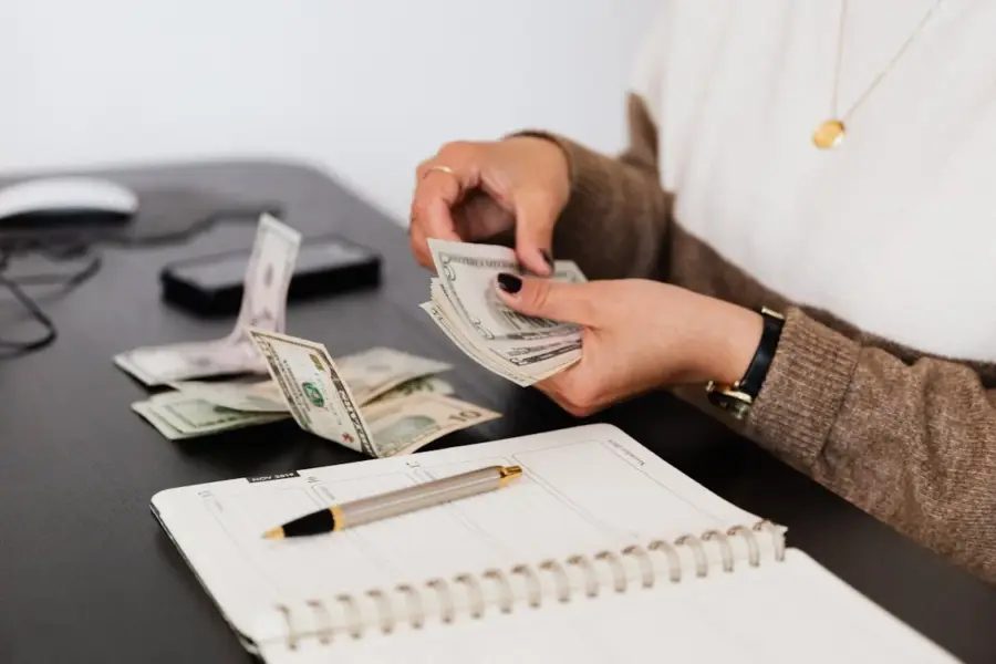 Person counting cash money and budgeting for vacation