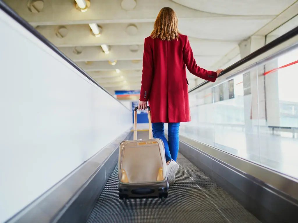 Traveler wearing their heaviest clothing items, including a jacket, to save space in their luggage.