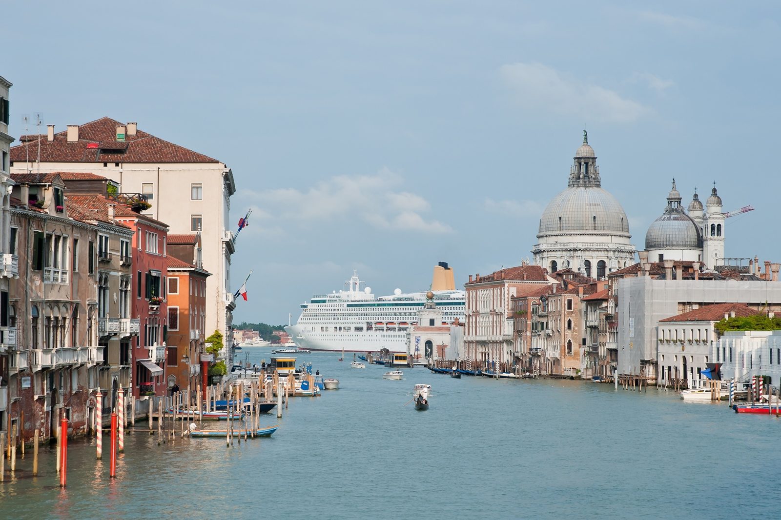 A crowded historic street lined with old buildings, illustrating the pressure of tourism on popular destinations.