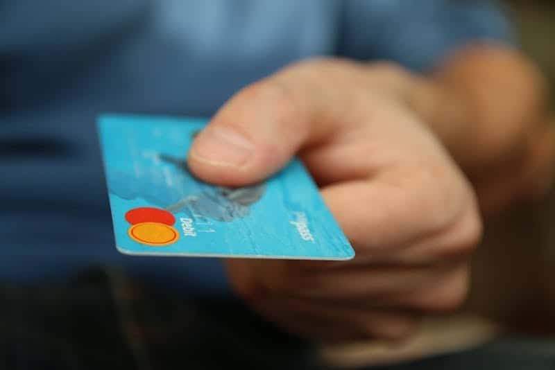 Debit card and cash on a table illustrating how hotel deposits can tie up real funds