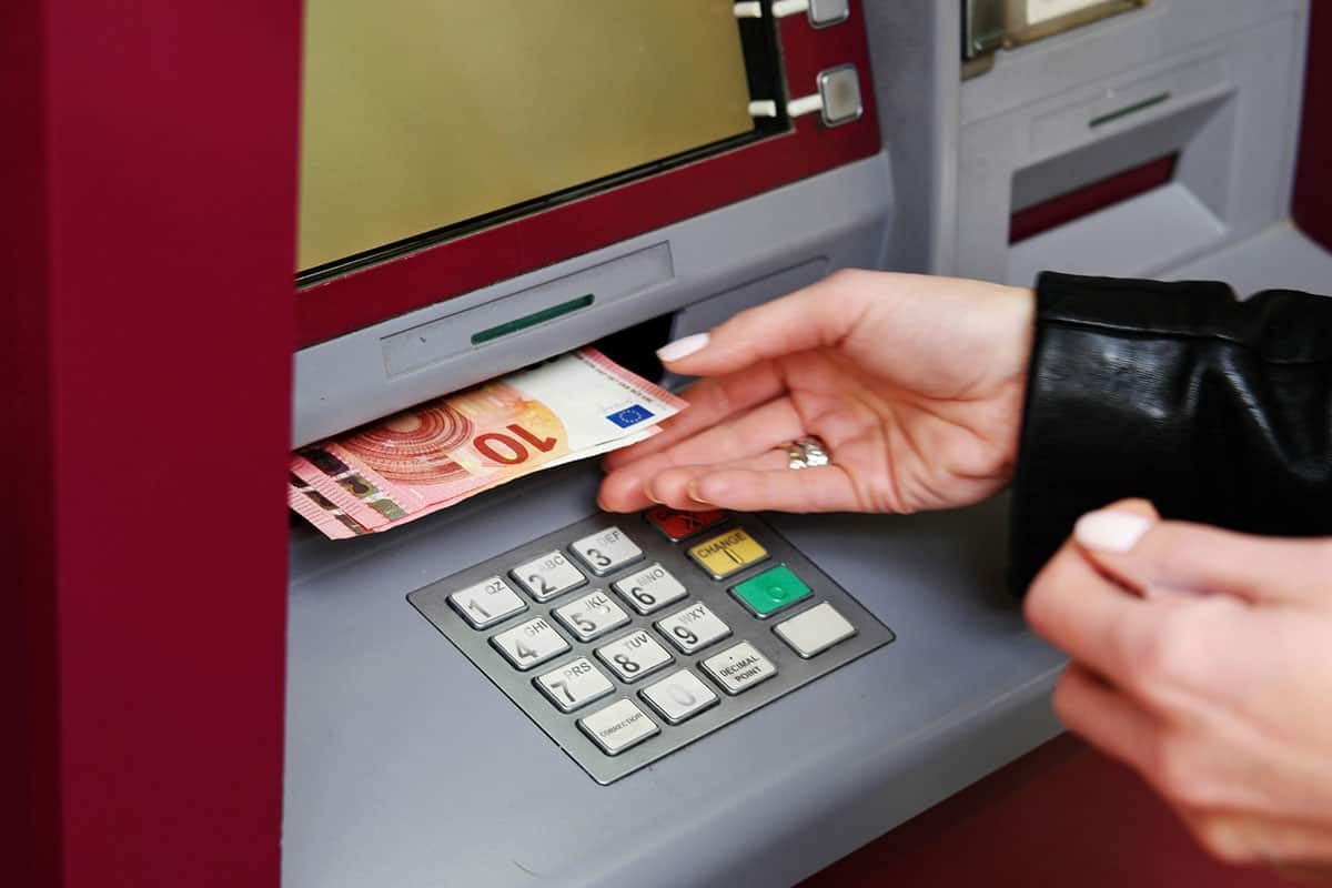 solo traveler taking money out of an ATM