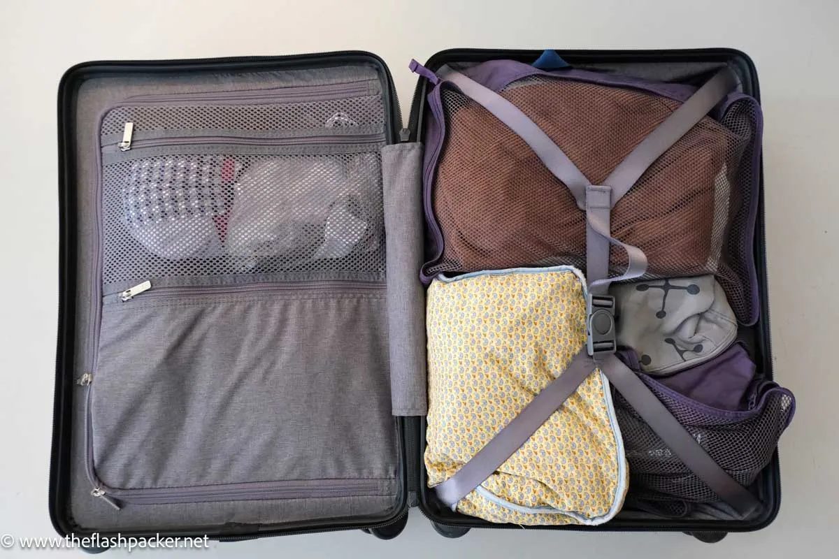 Carry-on suitcase packed with capsule wardrobe for 2 week trip using packing cubes