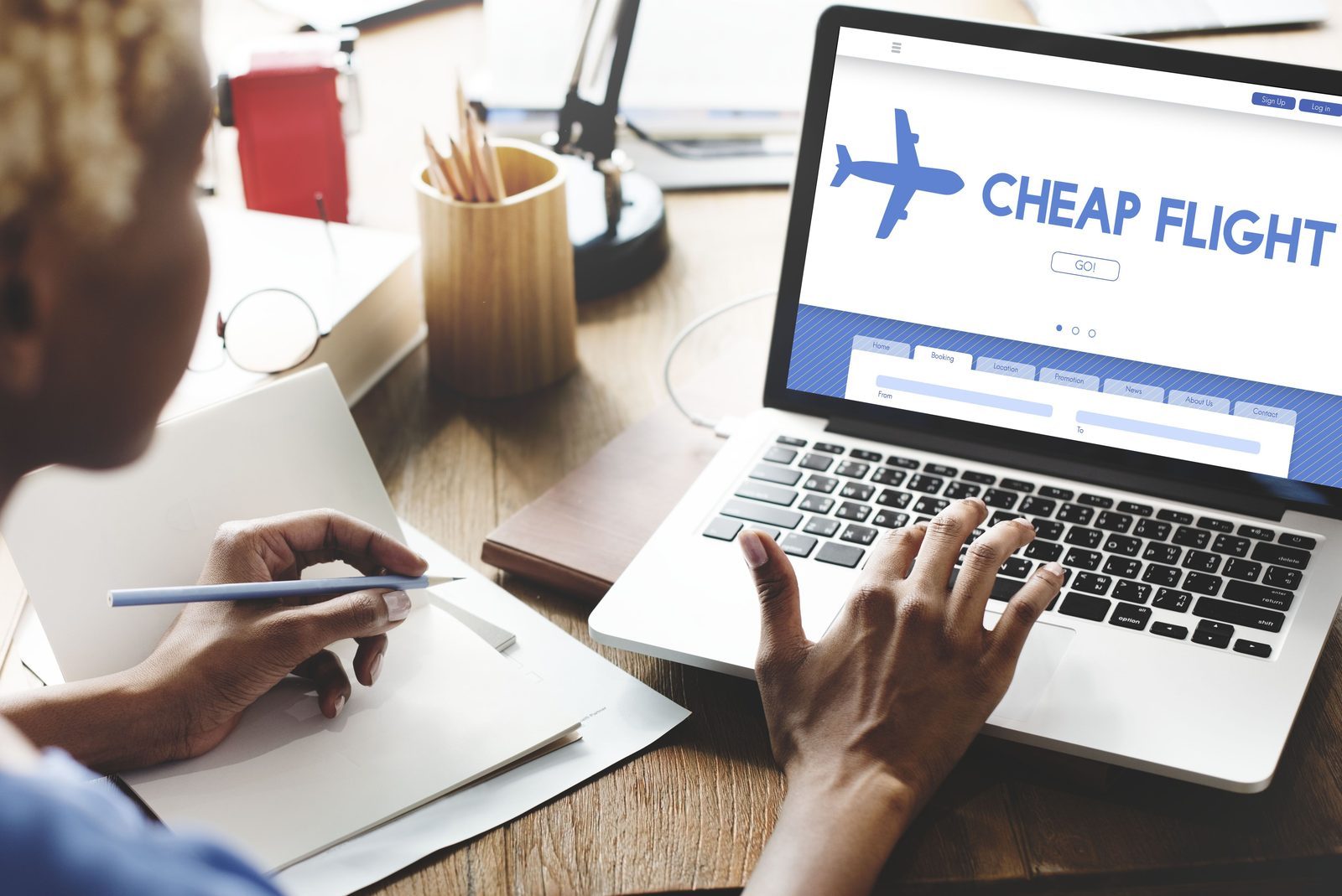 Woman looking at a cheap flight website on a laptop