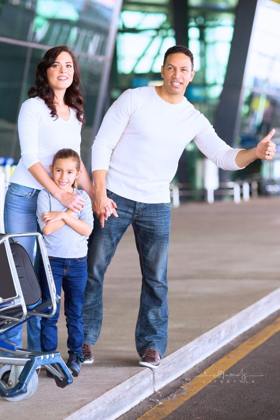 Family hailing a car at the airport, illustrating the choice between taxis, rideshares, and pre-booked transfers