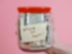 A jar with cash labeled 'Where to next?' against a pink background, suggesting travel or saving goals.