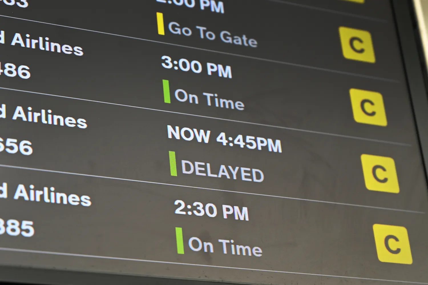 An airport departure board showing a flight delay