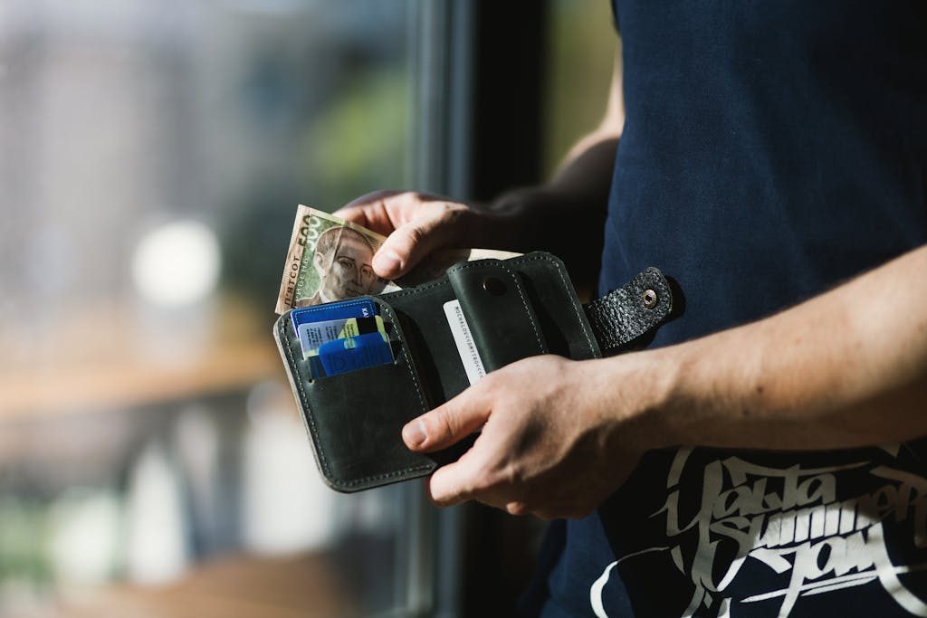 Traveler holding a wallet with cash and cards ready for expenses