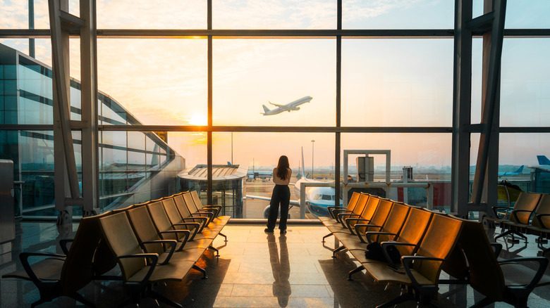 Traveler watching a plane take off, reflecting on a simple, flexible itinerary