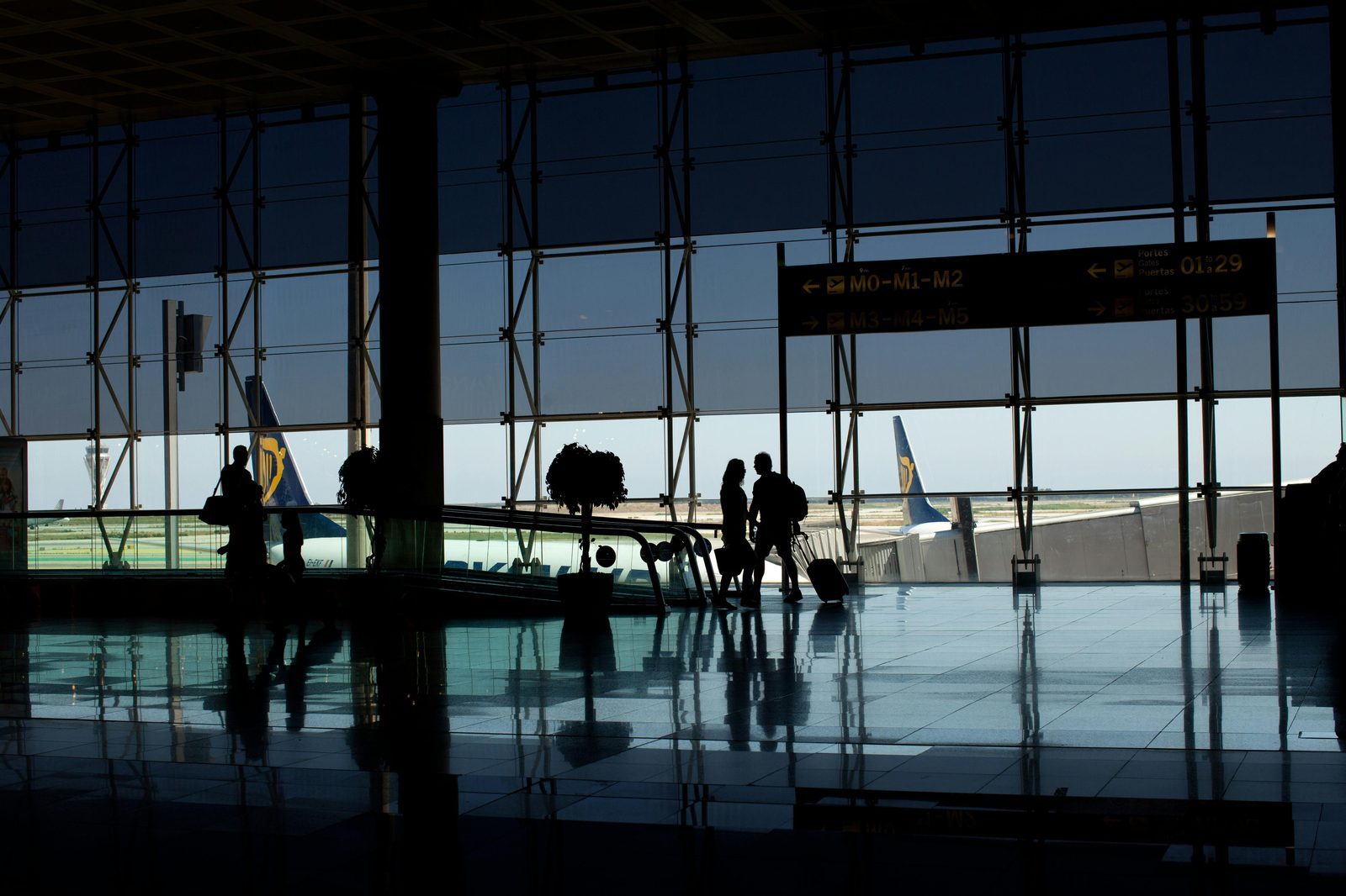 Traveler rolling suitcase at airport terminal