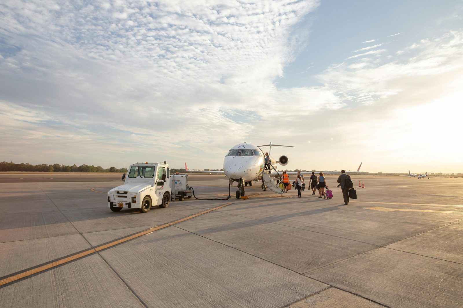 Passenger boarding a plane during sunset