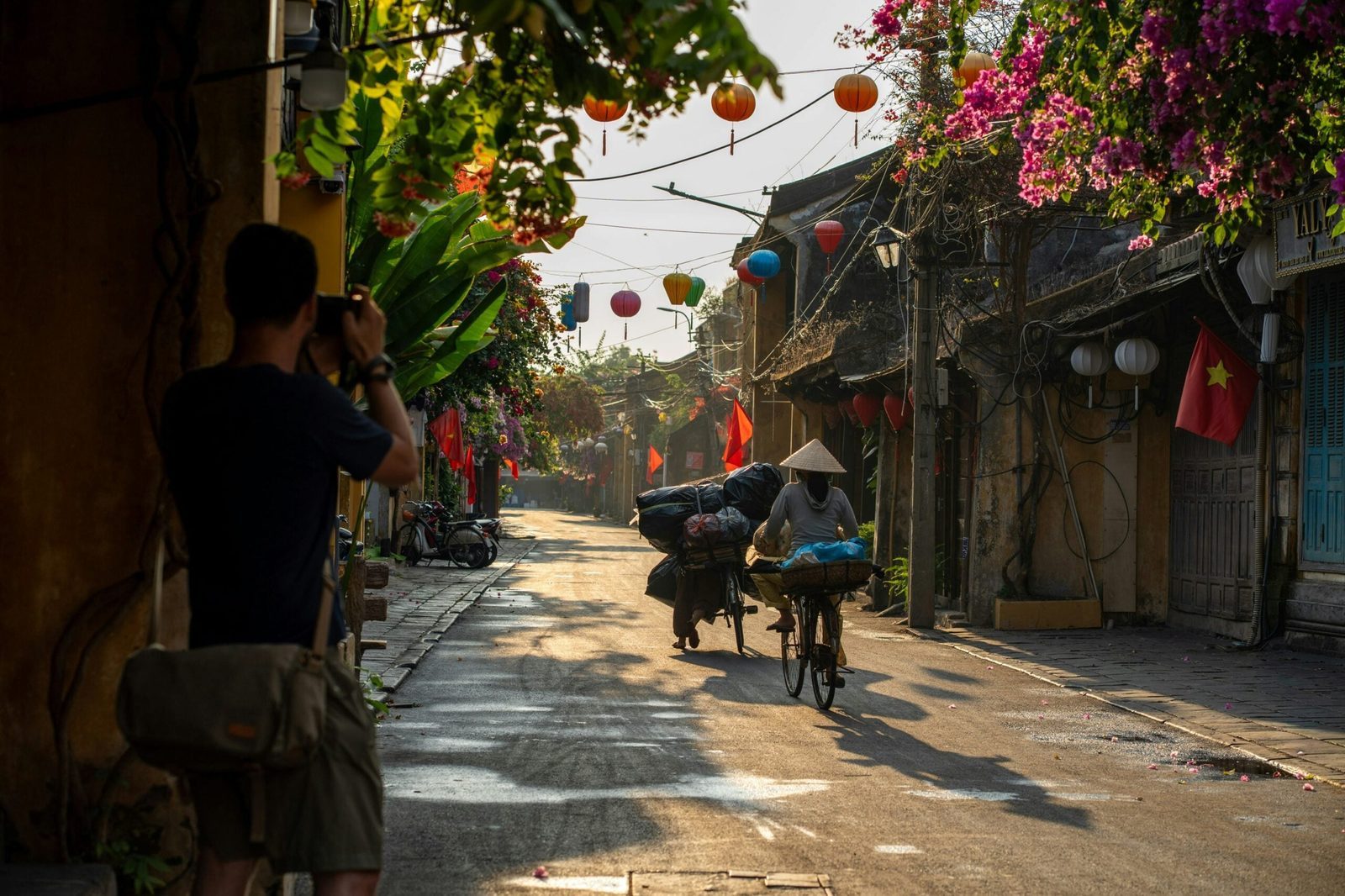 Sunrise on Hoi An's quiet streets with photographer taking picture of person on bike