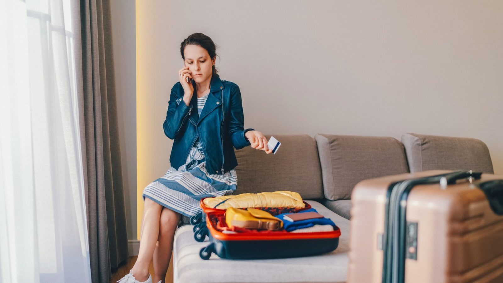 Traveler in a hotel room on the phone, reviewing unexpected charges