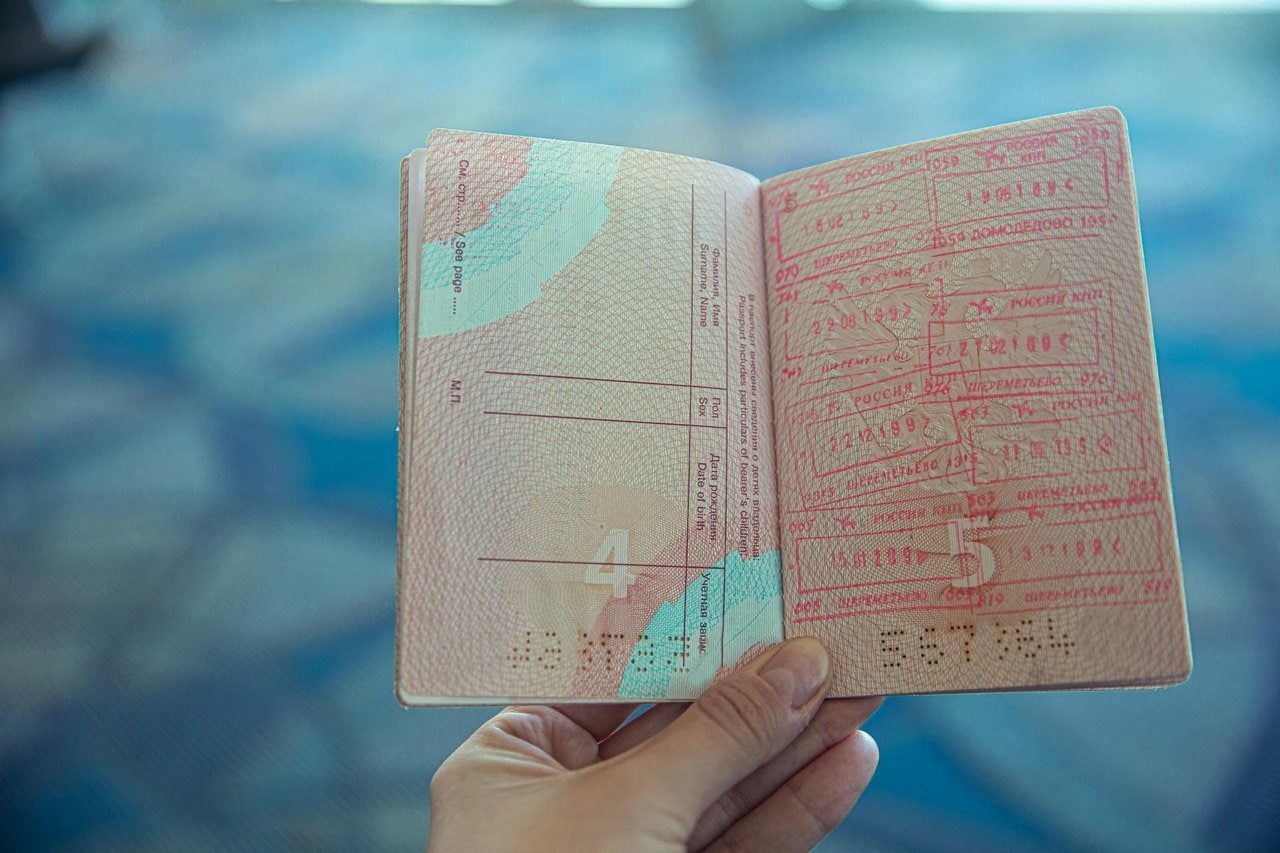 Passport with multiple immigration stamps, highlighting the complexity of international self-transfers