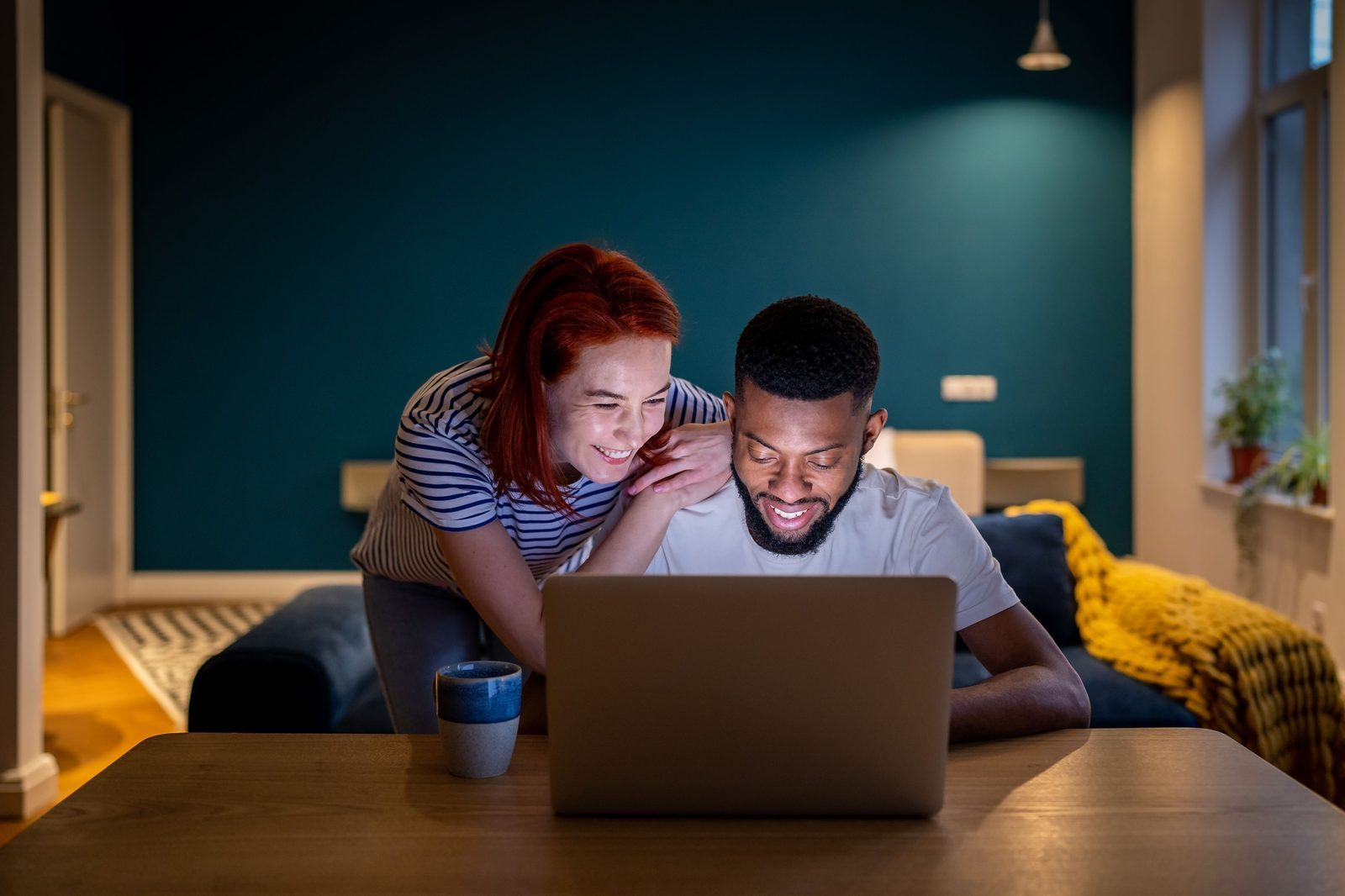 Two travelers booking flights on a laptop, comparing different departure times