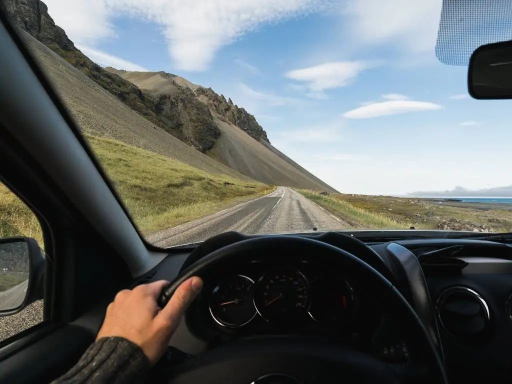 Driving on a scenic road in Iceland, combining transport and travel experience.