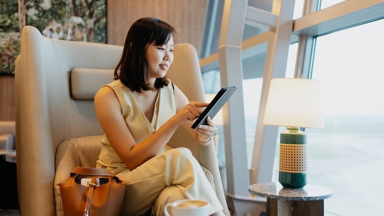 Business traveler using a tablet while waiting in an airport lounge