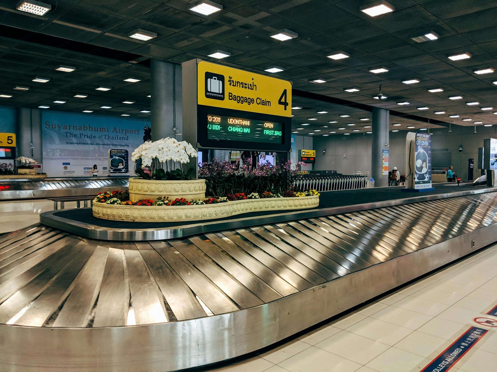 Suitcases lined up at an airport check-in area, highlighting the risks of checked baggage on separate tickets